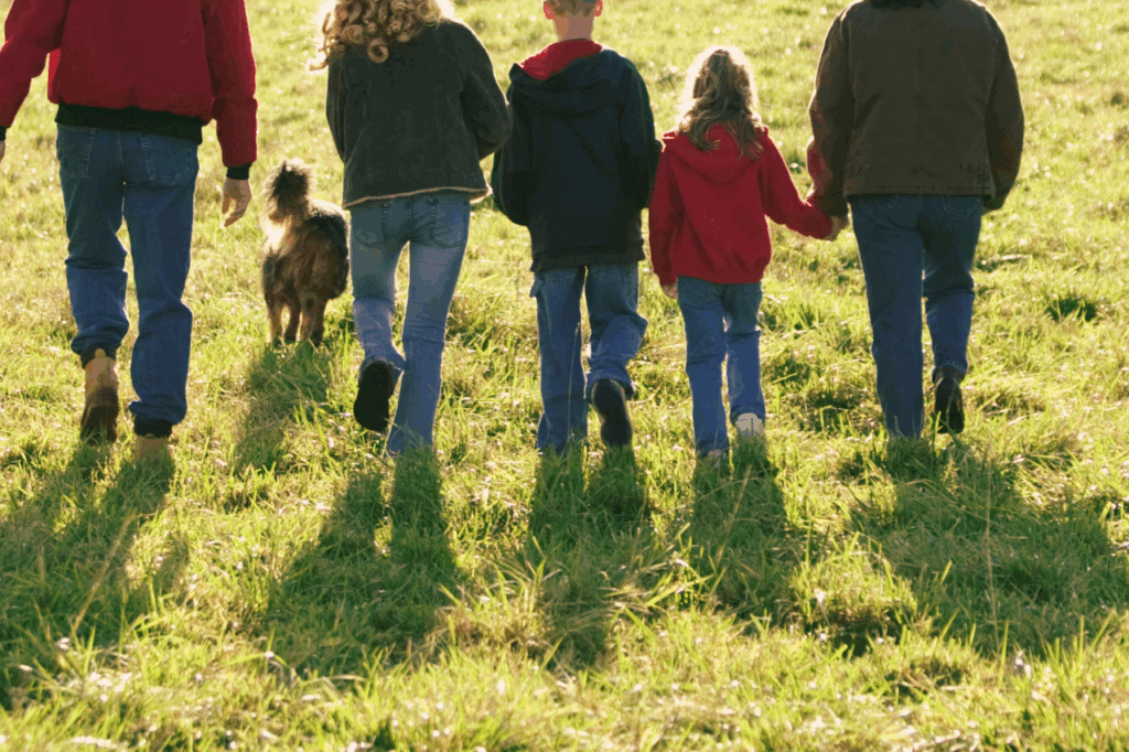 Systemisch werken nicoaching familie opstelling familie met kinderen die door het gras loopt